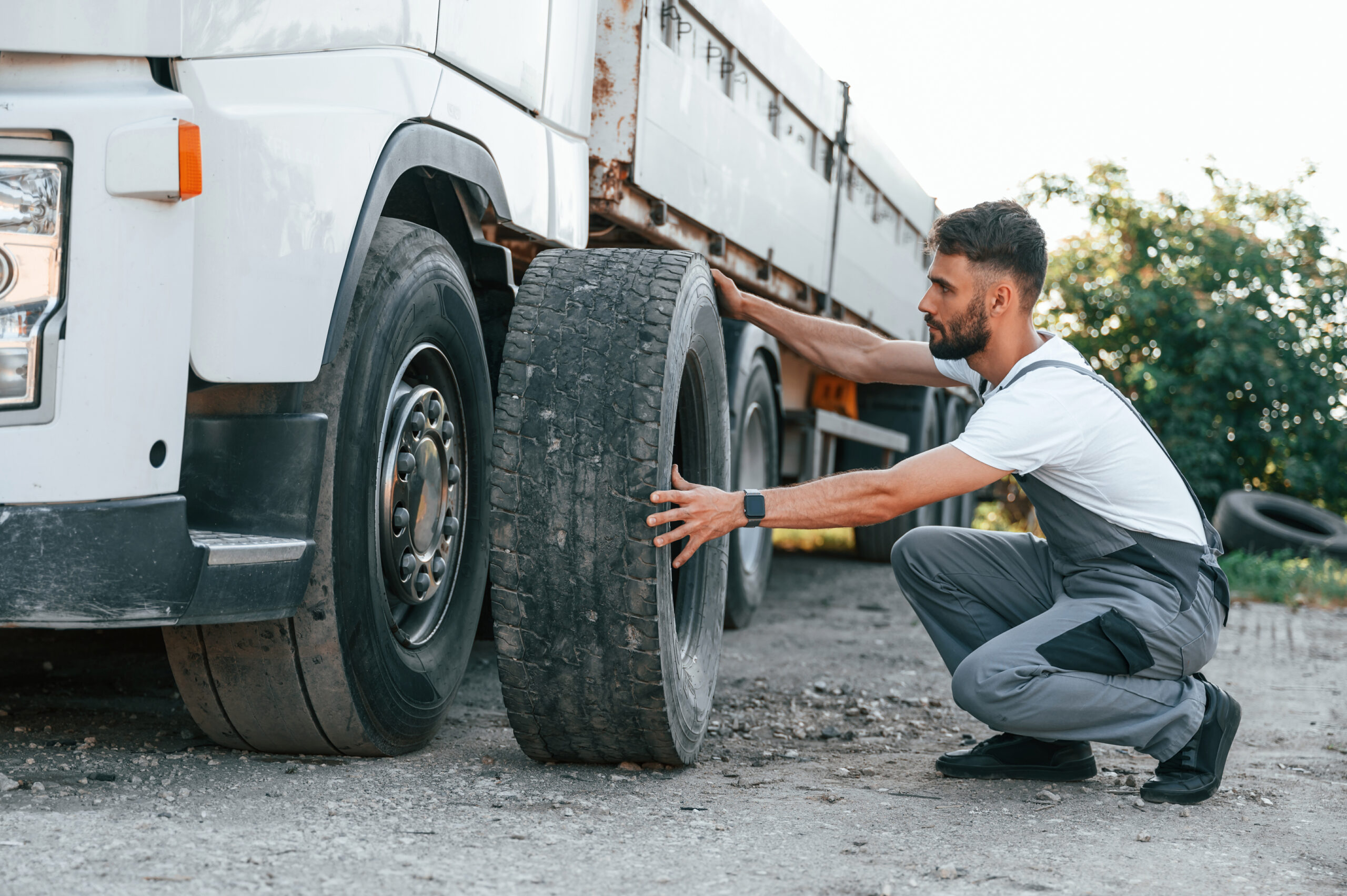 Proteção Veicular Caminhão - changing tire man unifrom doing service big truck vehicle scaled